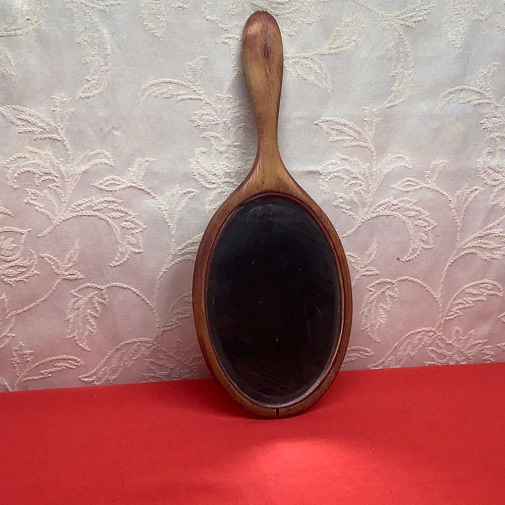 Vintage wooden hand mirror.  Mirror is beveled. Wood is distressed / cracked.